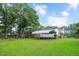 Spacious backyard showcasing a brick home and carport, enhanced by a lush, green lawn at 202 Hamilton Rd, Bunnlevel, NC 28323