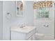 All white bathroom with window, mirror, sink, and toilet at 202 Hamilton Rd, Bunnlevel, NC 28323