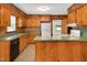 A kitchen view with wood paneling, wood cabinets, a peninsula, and white appliances at 202 Hamilton Rd, Bunnlevel, NC 28323