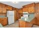 A view of the kitchen featuring wood paneling, wood cabinets, and white appliances at 202 Hamilton Rd, Bunnlevel, NC 28323