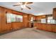 An open room featuring wood paneling, a window AC unit, and a glimpse into the kitchen at 202 Hamilton Rd, Bunnlevel, NC 28323