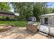 Backyard featuring a stone patio with outdoor kitchen, fire pit, and storage building at 203 W Boundary St, Cary, NC 27513