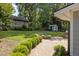 Landscaped backyard featuring a stone firepit, outdoor kitchen, patio, and storage building at 203 W Boundary St, Cary, NC 27513