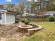 Backyard with brick patio and unique stone fire pit area with built-in seating at 203 W Boundary St, Cary, NC 27513