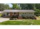 Charming single story home with red brick, grey siding, metal roof and manicured landscaping at 203 W Boundary St, Cary, NC 27513