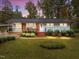 Charming single-story home featuring a brick facade, well-maintained landscaping, and a metal roof at 203 W Boundary St, Cary, NC 27513