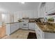 Well-lit kitchen featuring white cabinetry, granite countertops, and tile flooring at 203 W Boundary St, Cary, NC 27513
