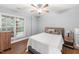 Cozy bedroom featuring hardwood floors, ceiling fan, and natural light through large windows at 205 Slate Blue Pl, Cary, NC 27519