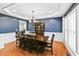 Open-concept dining area featuring hardwood floors, modern lighting, and a glimpse into the adjacent rooms at 205 Slate Blue Pl, Cary, NC 27519