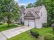 Stunning exterior view of a home with a stone facade, two-car garage, and manicured lawn at 205 Slate Blue Pl, Cary, NC 27519