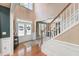 Elegant foyer featuring hardwood floors, a staircase, and a view into the adjacent living spaces at 205 Slate Blue Pl, Cary, NC 27519