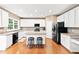 Bright kitchen features white cabinets, stainless appliances, granite counters, hardwood floors, and island with bar seating at 205 Slate Blue Pl, Cary, NC 27519