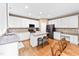 Bright kitchen features white cabinets, stainless appliances, granite counters, hardwood floors, and island with bar seating at 205 Slate Blue Pl, Cary, NC 27519