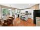 Bright kitchen features white cabinets, stainless appliances, granite counters, hardwood floors, and island with bar seating at 205 Slate Blue Pl, Cary, NC 27519