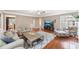 Open concept living room features wood floors, a fireplace, a large TV, and access to the kitchen and dining area at 205 Slate Blue Pl, Cary, NC 27519