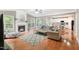 Open concept living room features wood floors, a fireplace, a large TV, and access to the kitchen and dining area at 205 Slate Blue Pl, Cary, NC 27519