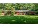 Charming brick home boasts a lush green lawn and mature trees, creating a welcoming curb appeal at 2053 Nottingham Ln, Burlington, NC 27215