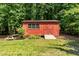Red shed surrounded by lush greenery in backyard at 2053 Nottingham Ln, Burlington, NC 27215