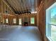 Spacious unfinished living room with fireplace, backyard entrance, and ample natural light at 209 Atkins Rd, Cameron, NC 28326