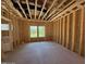 Unfinished bedroom area featuring exposed framing and window views to the outside at 235 Atkins Rd, Cameron, NC 28326