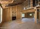Unfinished living room showcasing exposed framing, a cozy fireplace, and natural light from the windows at 235 Atkins Rd, Cameron, NC 28326