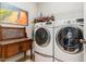 Bright laundry room with front-load washer and dryer and unique wooden folding table at 241 Serenity Hill Circle Cir, Chapel Hill, NC 27516