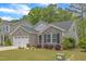 Charming stone and vinyl siding home with manicured front yard and attached two car garage at 2634 Yellow Pine Rd, Raleigh, NC 27616