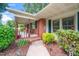 Inviting front porch with brick accents, rocking chairs, and lush landscaping enhancing curb appeal at 2925 Redwood Rd, Durham, NC 27704