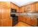Well-lit kitchen showcasing wood cabinets, granite countertops, and stainless steel appliances at 2925 Redwood Rd, Durham, NC 27704