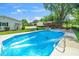 Inviting in-ground pool with lounge chairs, surrounded by a well-maintained yard and various outbuildings at 2925 Redwood Rd, Durham, NC 27704