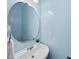 Powder room features a modern round mirror, sink, and fixtures at 308 Minton Valley Ln, Cary, NC 27519