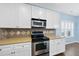 Well-lit kitchen featuring stainless steel oven and microwave with wood-look flooring at 308 Minton Valley Ln, Cary, NC 27519