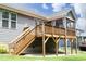 Back deck with stairs of home with gray siding, a fenced yard, and small trees at 309 Hines Point Dr, Rolesville, NC 27571