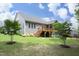 Backyard with gray siding, stairs, a deck, a green lawn, and small trees at 309 Hines Point Dr, Rolesville, NC 27571