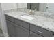 A bathroom vanity with granite countertop, gray cabinets, and modern fixtures, reflecting in a large mirror at 309 Hines Point Dr, Rolesville, NC 27571