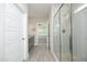 A modern bathroom showcasing a tiled shower and granite-topped vanity, with a bedroom visible through the doorway at 309 Hines Point Dr, Rolesville, NC 27571
