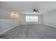 Spacious bonus room featuring plush carpet, a ceiling fan, and bright, natural light from large windows at 309 Hines Point Dr, Rolesville, NC 27571