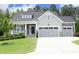 Charming home featuring a two-car garage, stone accents, a cozy porch, and manicured landscaping at 309 Hines Point Dr, Rolesville, NC 27571
