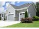 Spacious two-car garage with stone accents, well-maintained lawn, and lush landscaping in a peaceful setting at 309 Hines Point Dr, Rolesville, NC 27571