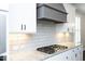 Close up of kitchen range and tile backsplash and granite countertops at 309 Hines Point Dr, Rolesville, NC 27571