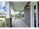 Spacious, covered porch featuring stone columns and a view of a quiet neighborhood street at 309 Hines Point Dr, Rolesville, NC 27571
