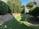 A serene backyard featuring a lush lawn, stone pathways, and mature landscaping for a tranquil retreat at 3129 Elm Tree Ln, Raleigh, NC 27614