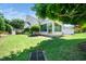 A well maintained lawn with trees provides shade for this home's screened-in porch at 3129 Elm Tree Ln, Raleigh, NC 27614
