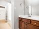 Bathroom with cherry wood vanity, white countertop, mirror and a shower/tub combo in the background at 3129 Elm Tree Ln, Raleigh, NC 27614