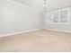 Spacious bedroom with carpet, large windows, and a modern light fixture at 3129 Elm Tree Ln, Raleigh, NC 27614