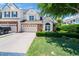 Charming home exterior featuring a manicured lawn, brick accents, and an attached two-car garage at 3129 Elm Tree Ln, Raleigh, NC 27614