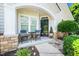 Inviting front porch with a charming seating area, stone accents, and a welcoming entryway at 3129 Elm Tree Ln, Raleigh, NC 27614