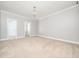 Spacious main bedroom with neutral carpet, crown molding and two open doorways at 3129 Elm Tree Ln, Raleigh, NC 27614