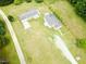 Expansive aerial view of a property featuring a two-story home, outbuilding, and surrounding green landscape at 3354 Altamahaw Church Rd, Elon, NC 27244