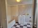 Bathroom featuring a shower-tub combo and a white vanity with checkerboard tile floors at 3354 Altamahaw Church Rd, Elon, NC 27244